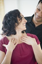 Smiling man giving wife elegant necklace