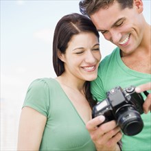 Smiling couple looking at back of digital camera together