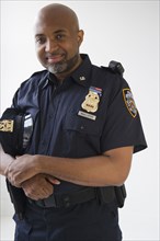 Smiling African American policeman holding cap