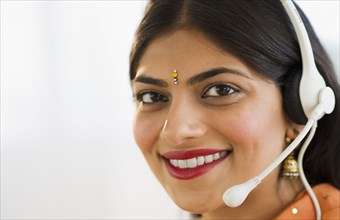 Indian woman in traditional Indian clothing talking on headset
