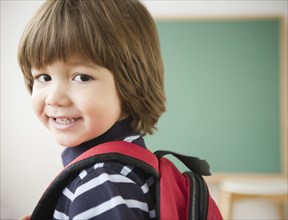 Smiling Hispanic boy wearing backpack
