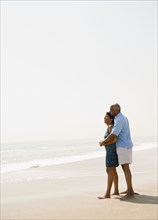 Black couple hugging on beach