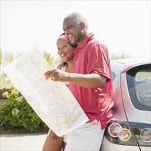 Black couple looking at road map together