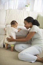 Mixed race woman playing with baby