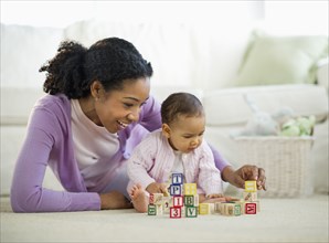 Mixed race woman playing with blocks with baby