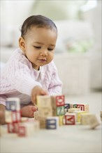 Mixed race baby playing with blocks