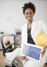 Black businesswoman holding solar panel