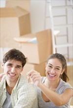 Excited couple holding keys to new home