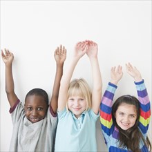 Friends standing with arms raised