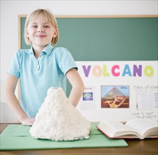 Caucasian girl standing with model volcano