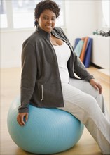 African American woman sitting on exercise ball