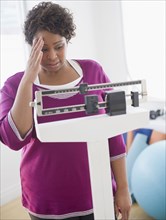 African American woman weighing herself