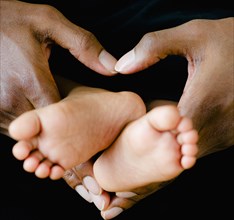 Father's hands holding tiny baby feet