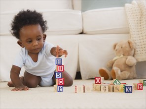 African American baby playing on floor with blocks