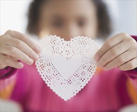 African American girl holding heart-shaped doily