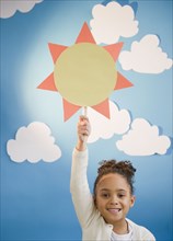 African American girl holding up paper sun