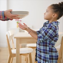 African American girl helping to set table