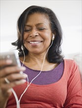 Mixed race woman listening to mp3 player