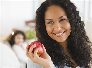 Mixed race woman holding red apple