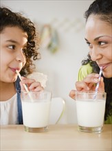 Mother and daughter drinking milk with straws