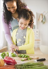 Mother and daughter chopping vegetables together