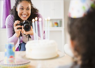 Mother taking birthday picture of daughter