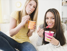 Teenage girls eating ice cream together
