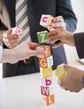Business people stacking alphabet blocks