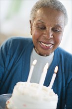Black woman looking at birthday cake