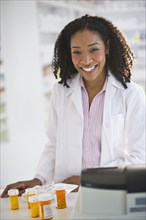 Smiling pharmacist working with medication