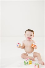 Mixed race baby playing with alphabet blocks