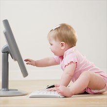 Caucasian baby playing with computer