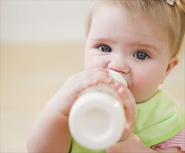 Caucasian baby drinking bottle