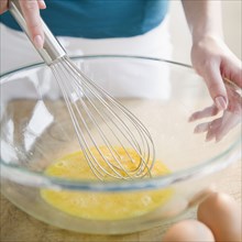 Korean woman whisking eggs in bowl