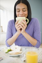 African American woman drinking coffee with breakfast