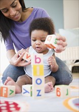 African American mother and son playing with alphabet blocks