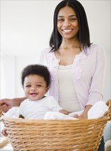 African American mother carrying baby boy in basket