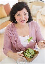 Hispanic woman eating salad for lunch