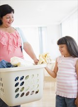Hispanic mother and daughter doing laundry