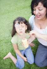 Hispanic mother and daughter blowing bubbles