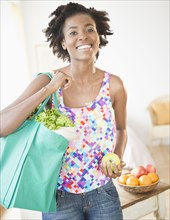 Black woman carrying reusable grocery bag