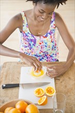 Black woman squeezing fresh orange juice