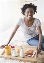 Black woman having breakfast in bed