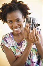 Black woman holding old-fashioned video camera