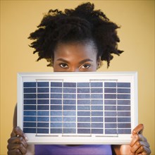 Black woman holding solar panel