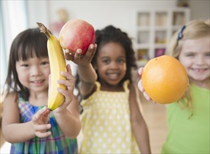 Children holding out fresh fruit
