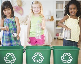 Children putting recyclable materials into recycling bins