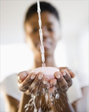 Water splashing on soap in Black woman's hands