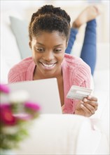 Black woman shopping online with credit card