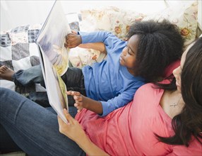 African American mother reading book to son